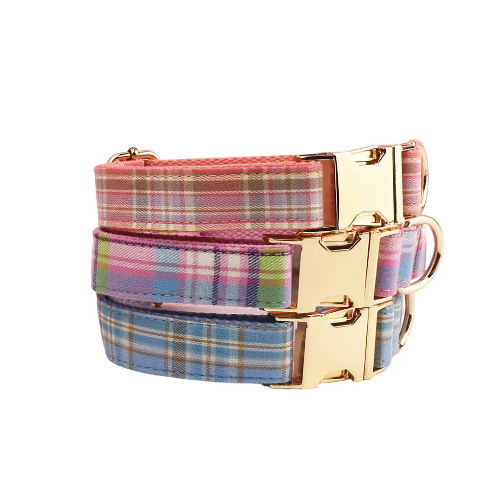 Plaid fabric dog collar, leash, bow, and vest four-piece accessory set on a white background.