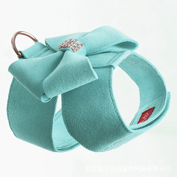 Close-up of a pink microfiber dog chest strap with a white bowknot and an adjustable metal buckle.