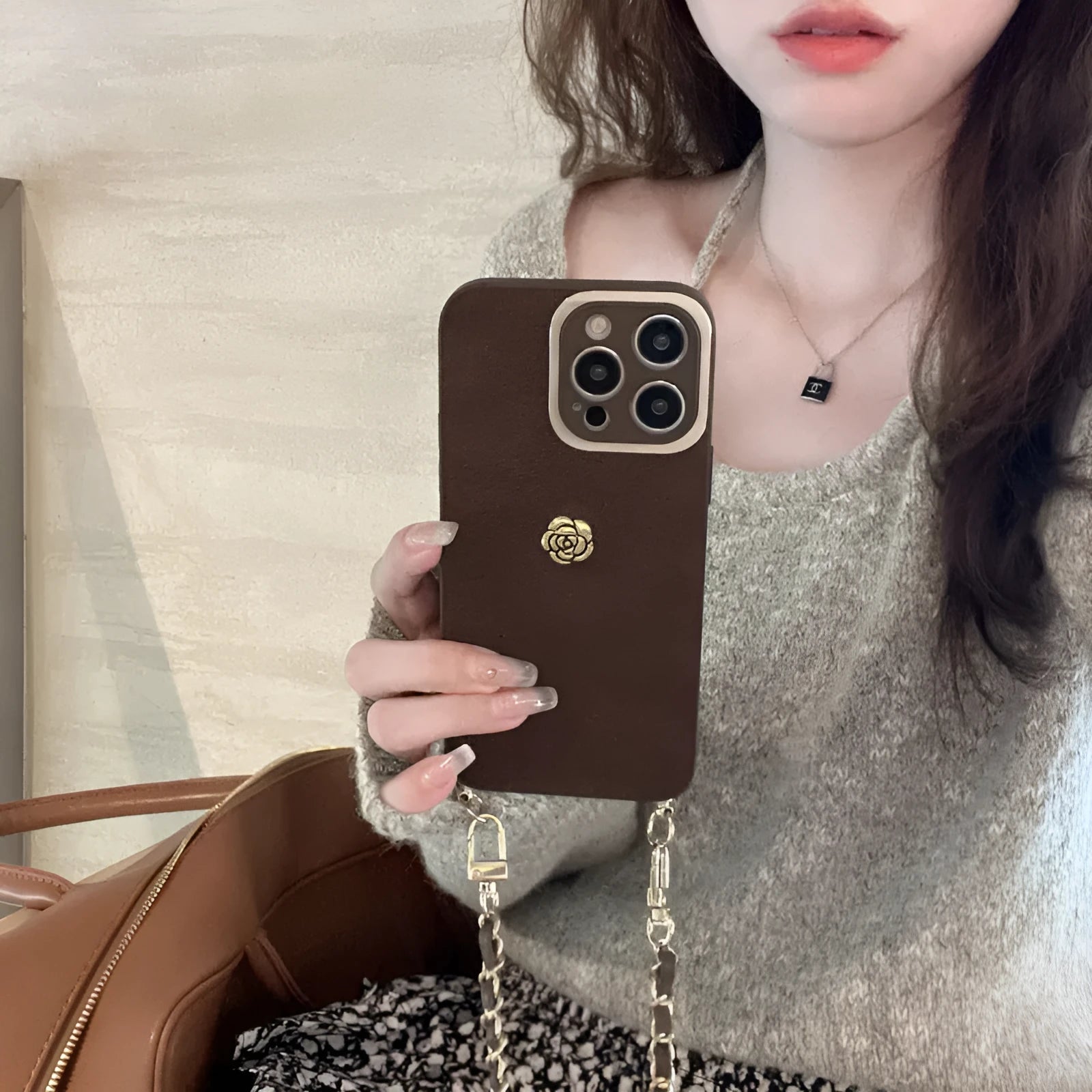 Maillard classic camellia phone case in brown with embossed pattern and adjustable crossbody strap