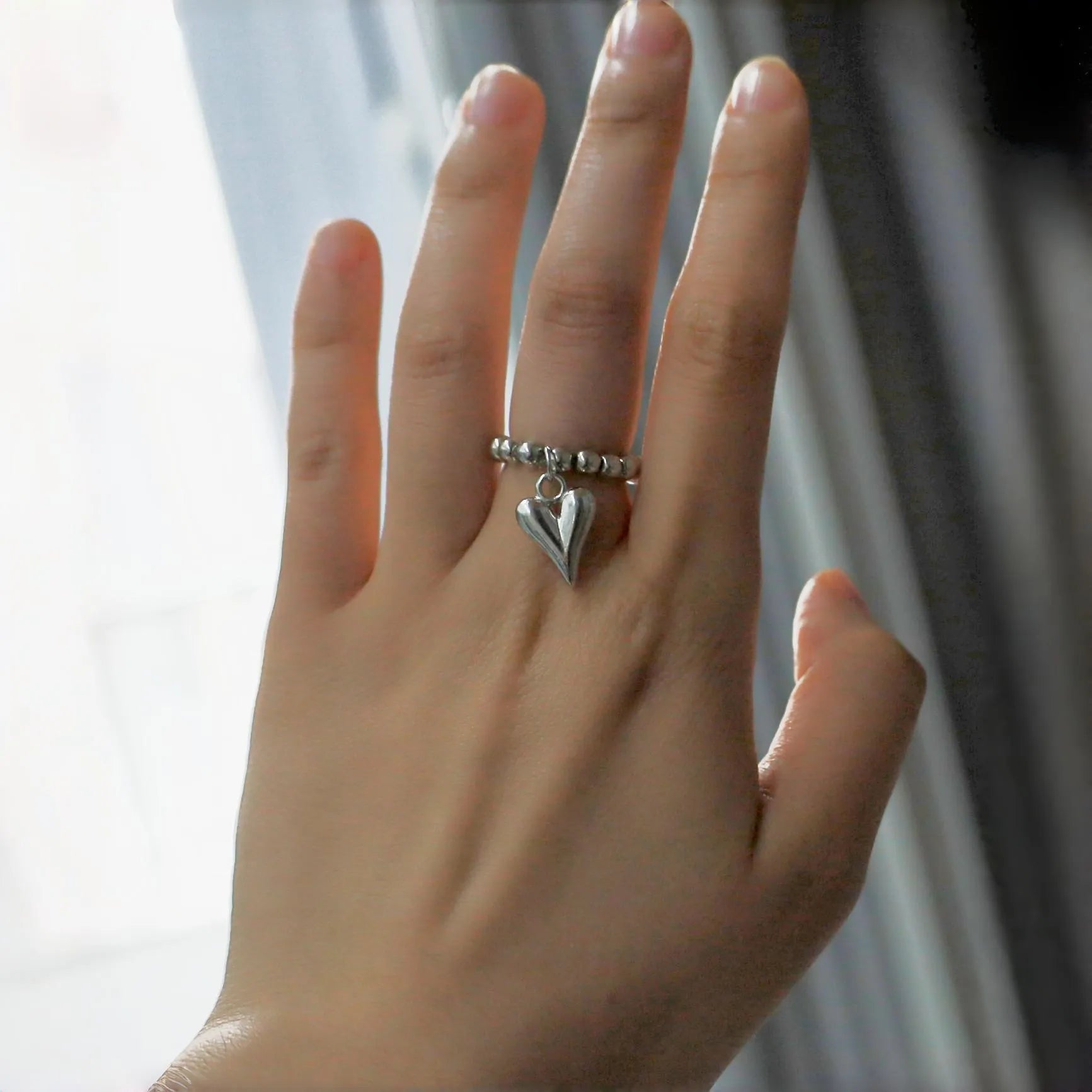 Handmade beaded elastic string love ring with geometric heart design in gold or white colours