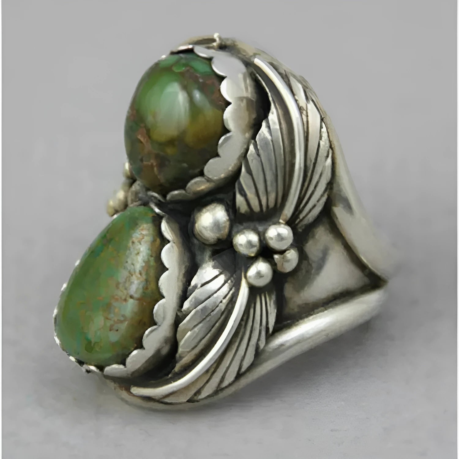 Women's geometric alloy ring with a turquoise coloured inlay, shown on a model's finger.