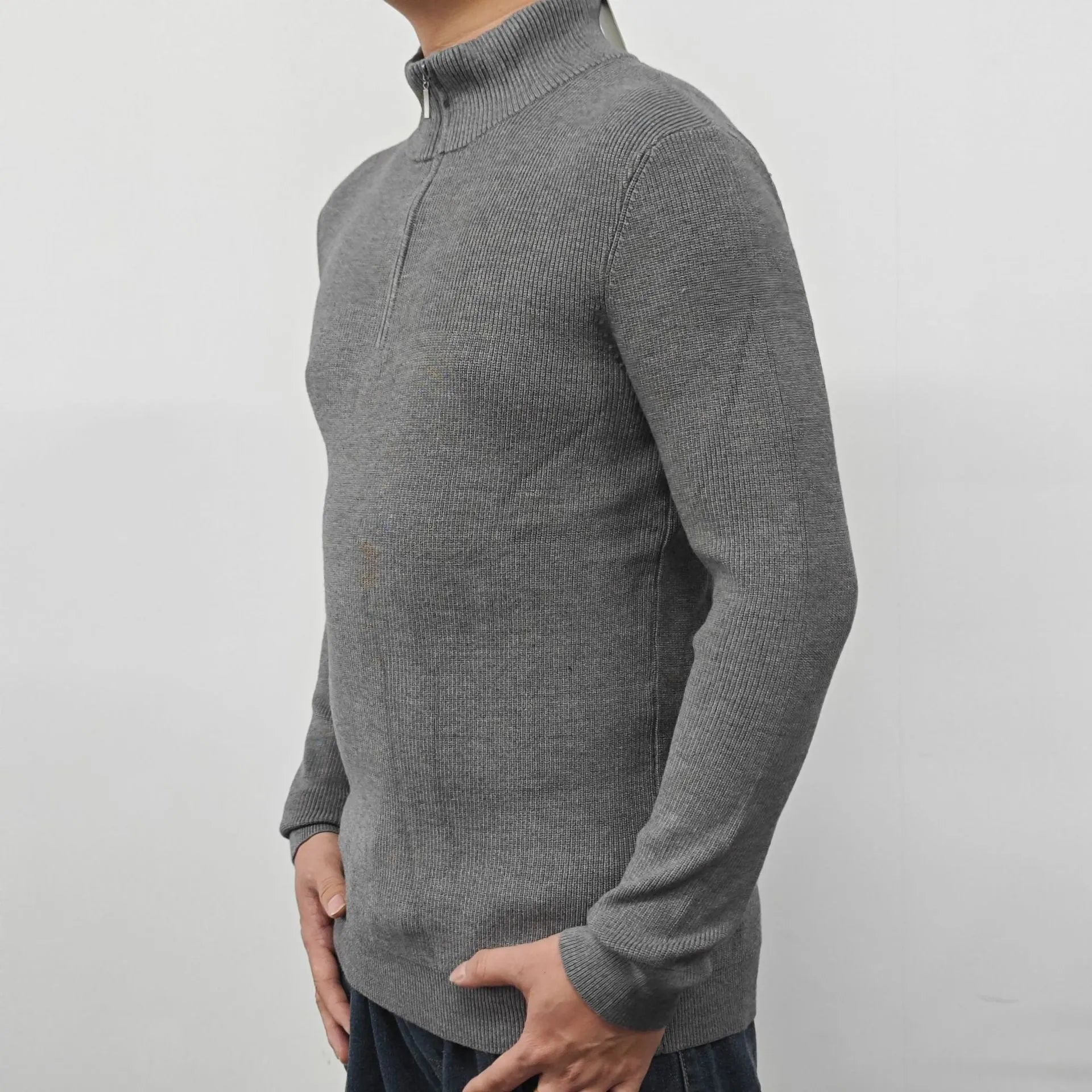 Man wearing a grey half-turtleneck zipper sweater, long sleeves, casual style.