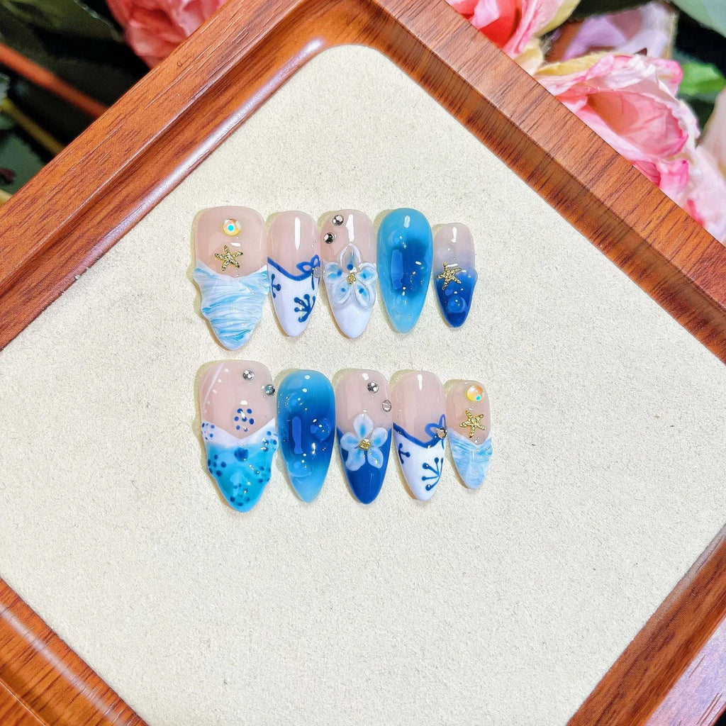 Blue hand-painted carved transparent fake nails set in sizes XS, S, M, L.