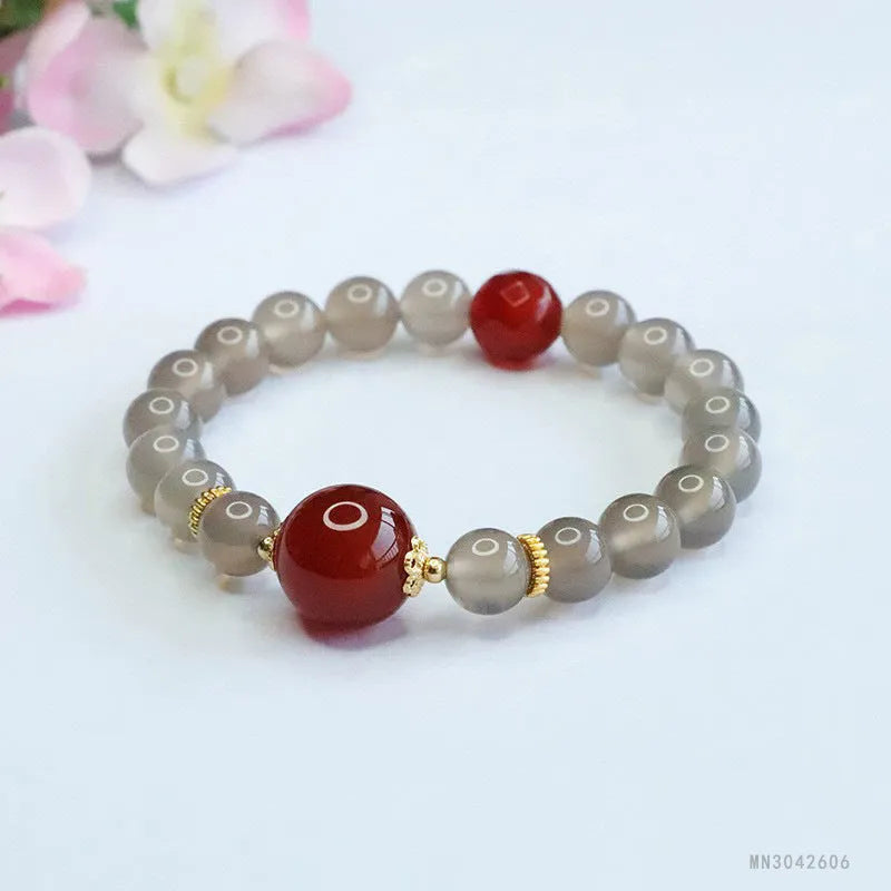 Smoky purple and red agate bracelet with 8mm geometric beads on a wrist.