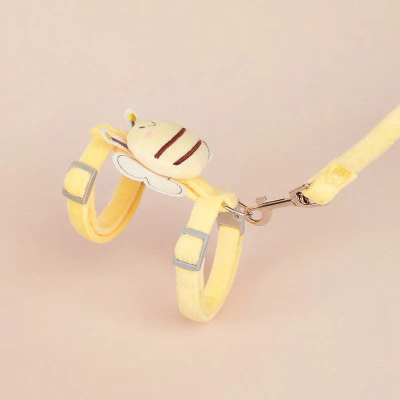 Pink teddy bee-shaped cat rope and adjustable hand-held lead on a green lawn.
