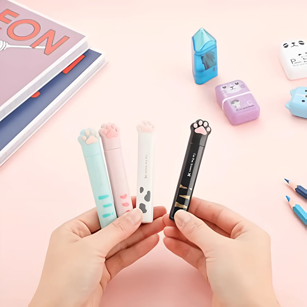 Set of four mini folding scissors with cat paw handles in pink, white, black, and blue colours, shown closed.