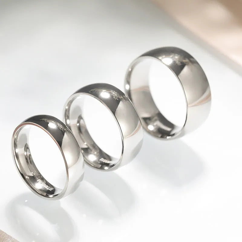 A polished silver titanium ring shown in three width options: 2mm, 4mm, and 6mm.