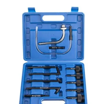 Thirteen-piece automatic transmission oil refuelling kit with pump tool and adapters on a workbench.