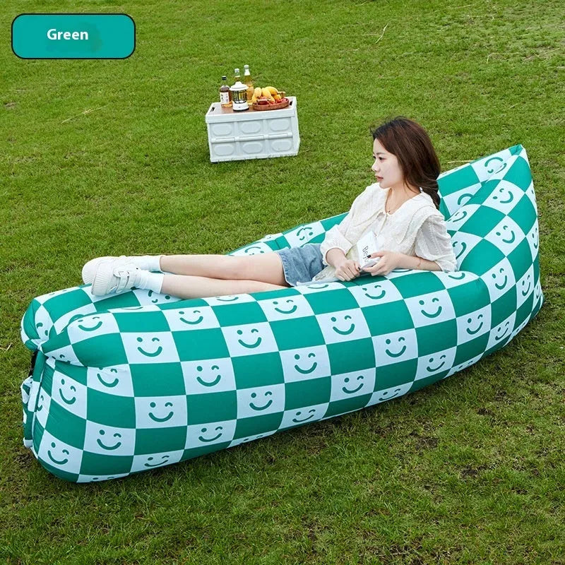 Yellow smiling face tip inflatable sofa inflated on green grass for camping