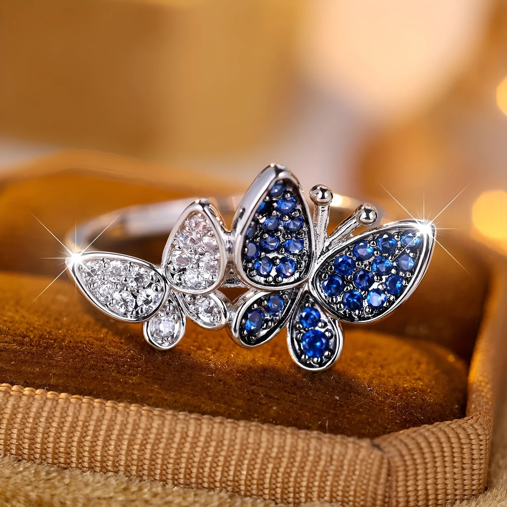 A blue and white electroplated butterfly ring for women, made from copper, shown in UK size 10.