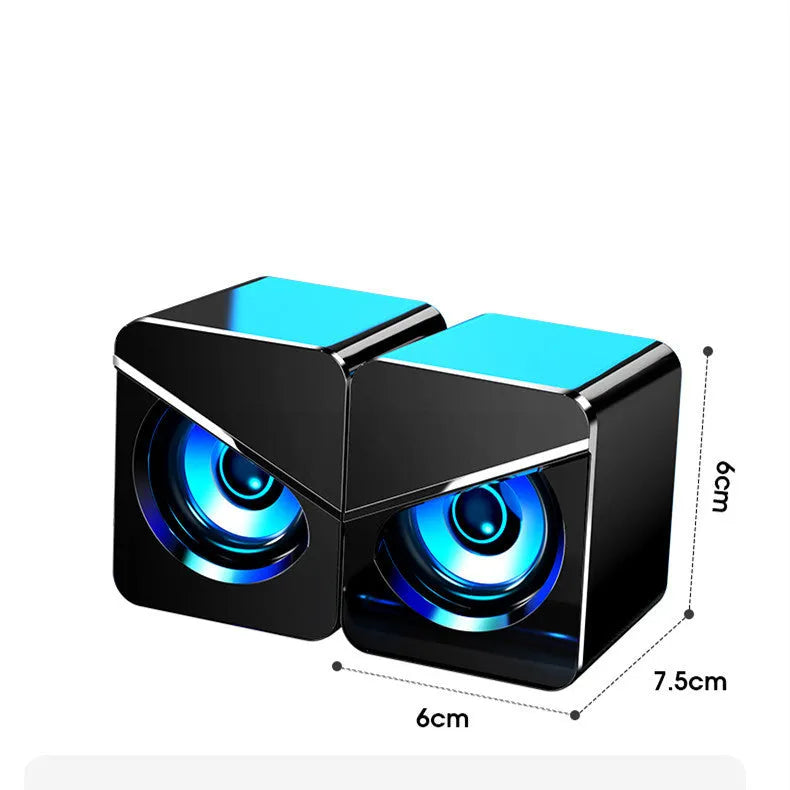 Black and white USB wired desktop computer speakers with volume knob on compact plastic housing.