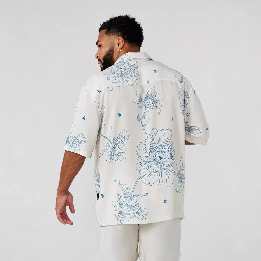 Man wearing a loose, short-sleeve floral print casual top in a cardigan style.