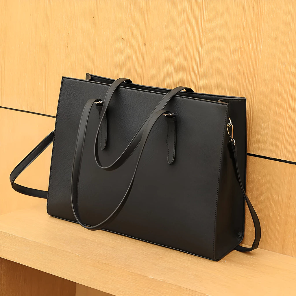 Large black women's business shoulder bag showing computer compartment and three adjustable straps