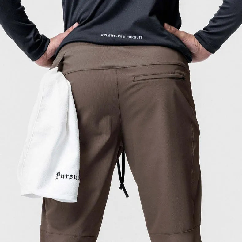 Man in loose grey fitness trousers with tied ankle cuffs, suitable for exercise.