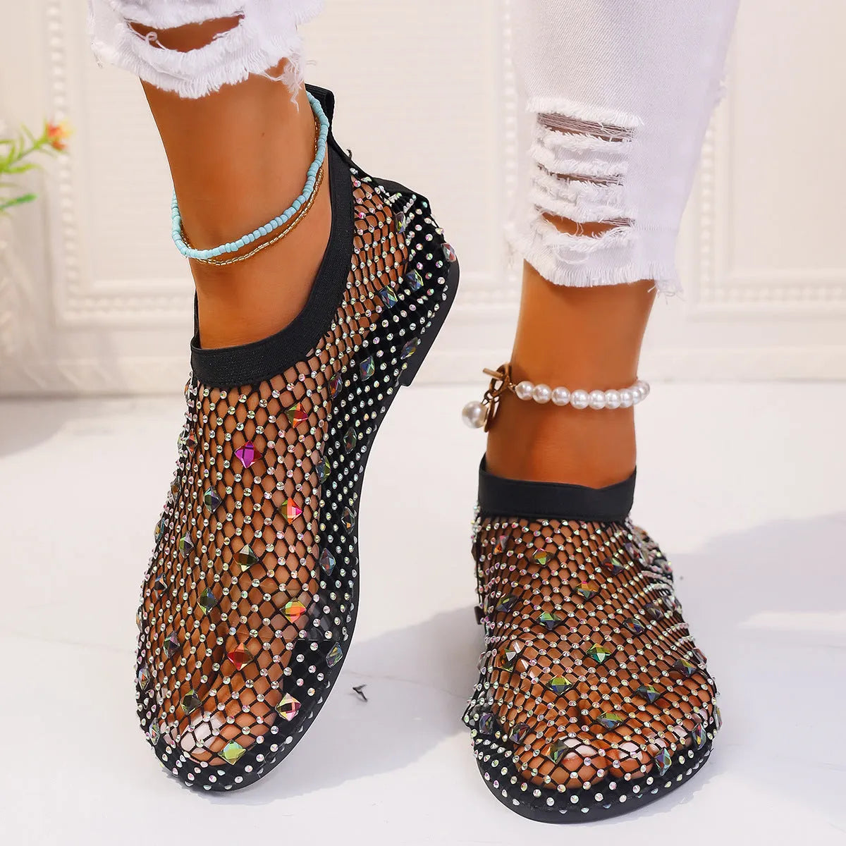 Women's flat sandals with mesh upper, colourful rhinestone design, and round toe on a rubber sole.