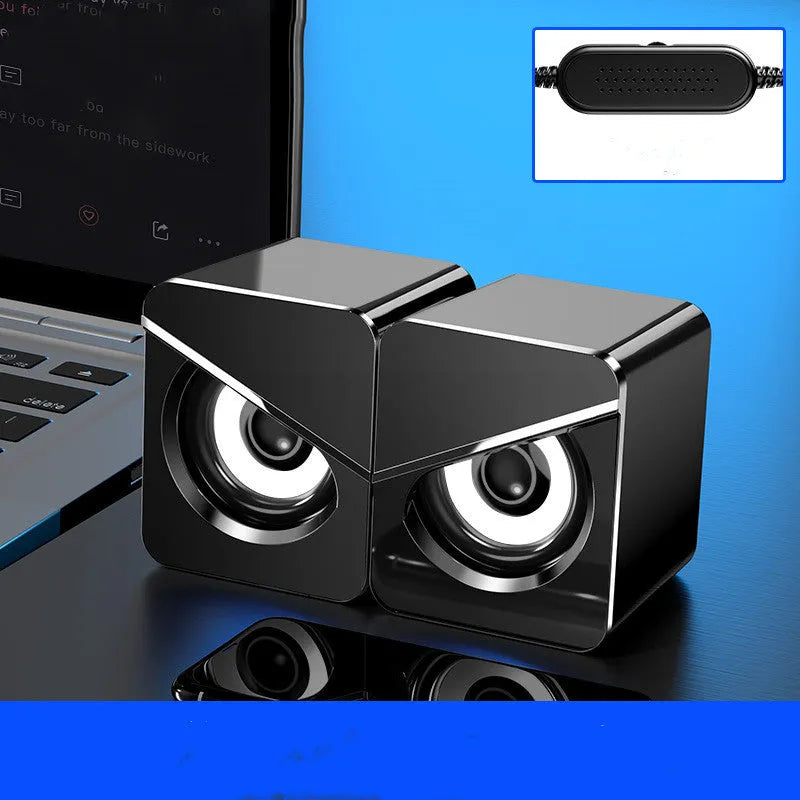Black and white USB wired desktop computer speakers with volume knob on compact plastic housing.