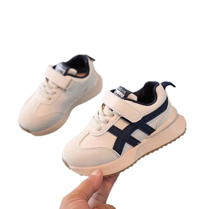 Children's white casual sneaker with Velcro strap and rubber sole on a neutral background.
