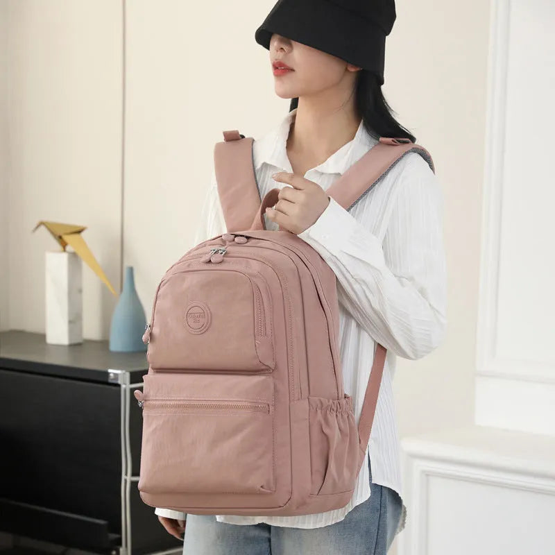 Women's large nylon travel backpack in celestite green showing front three-dimensional pocket and urban style.
