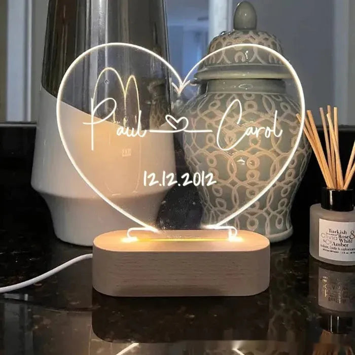Custom transparent acrylic night light showing personalised names and date, lit by an LED base.