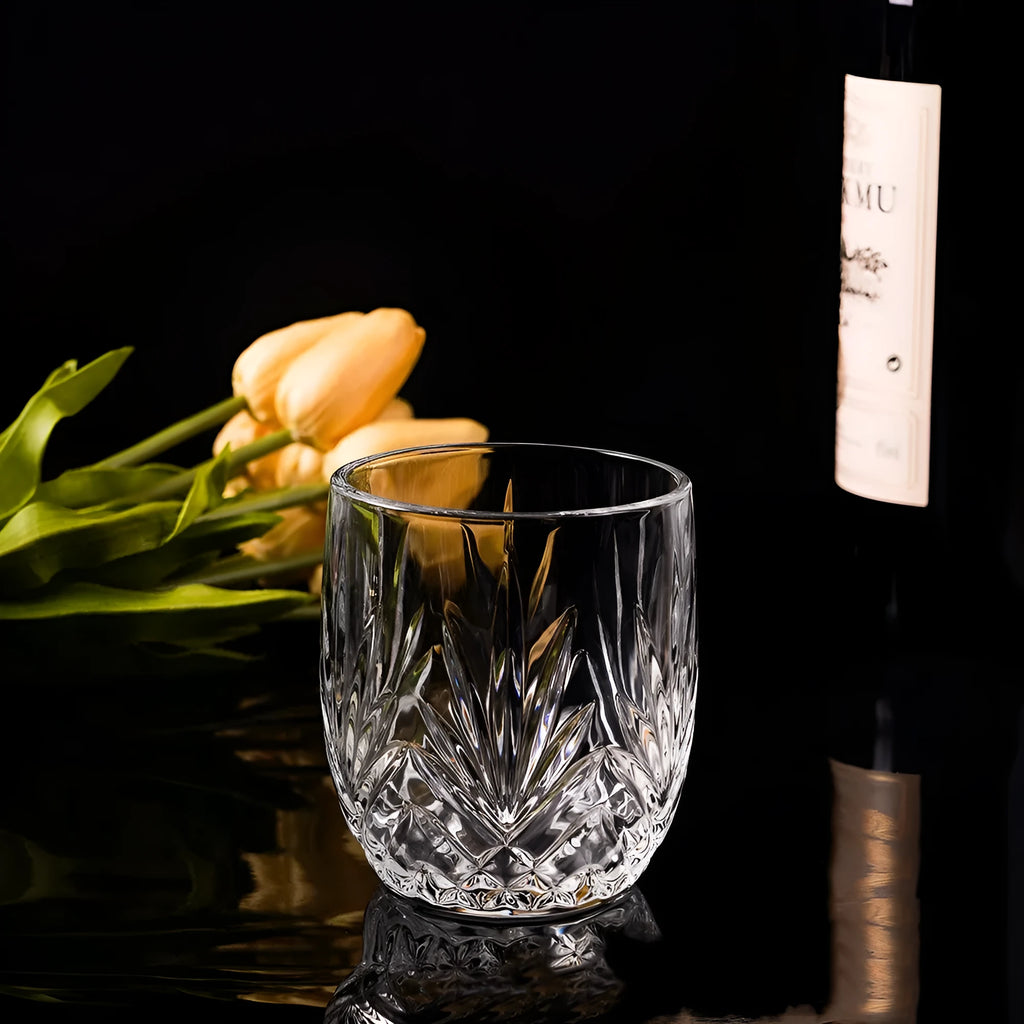 Clear whiskey shot glass with thick base and crystal design holding amber liquid
