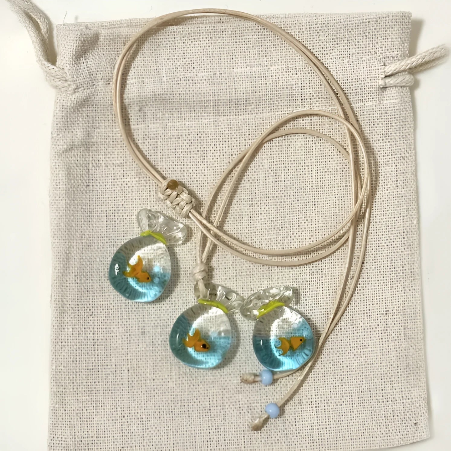 Women's pendant necklace with coloured glaze joker charm on a cotton and linen clavicle chain.