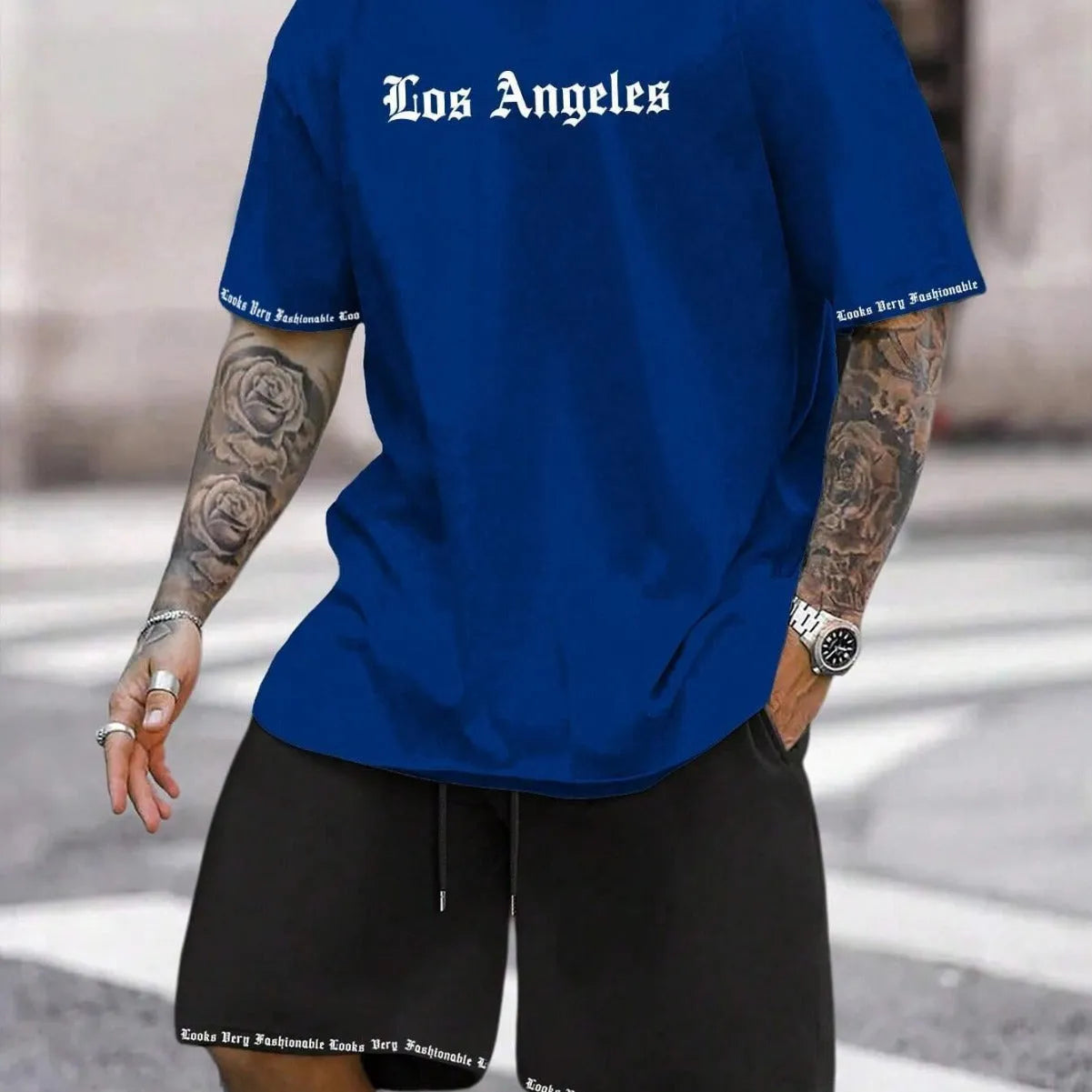 Man wearing a blue printed sports-style short-sleeve top and matching shorts set.
