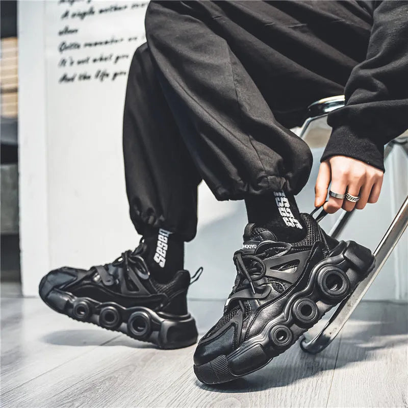 Men's low-top casual sneaker in black with mesh upper, thick rubber sole, and lace-up front.