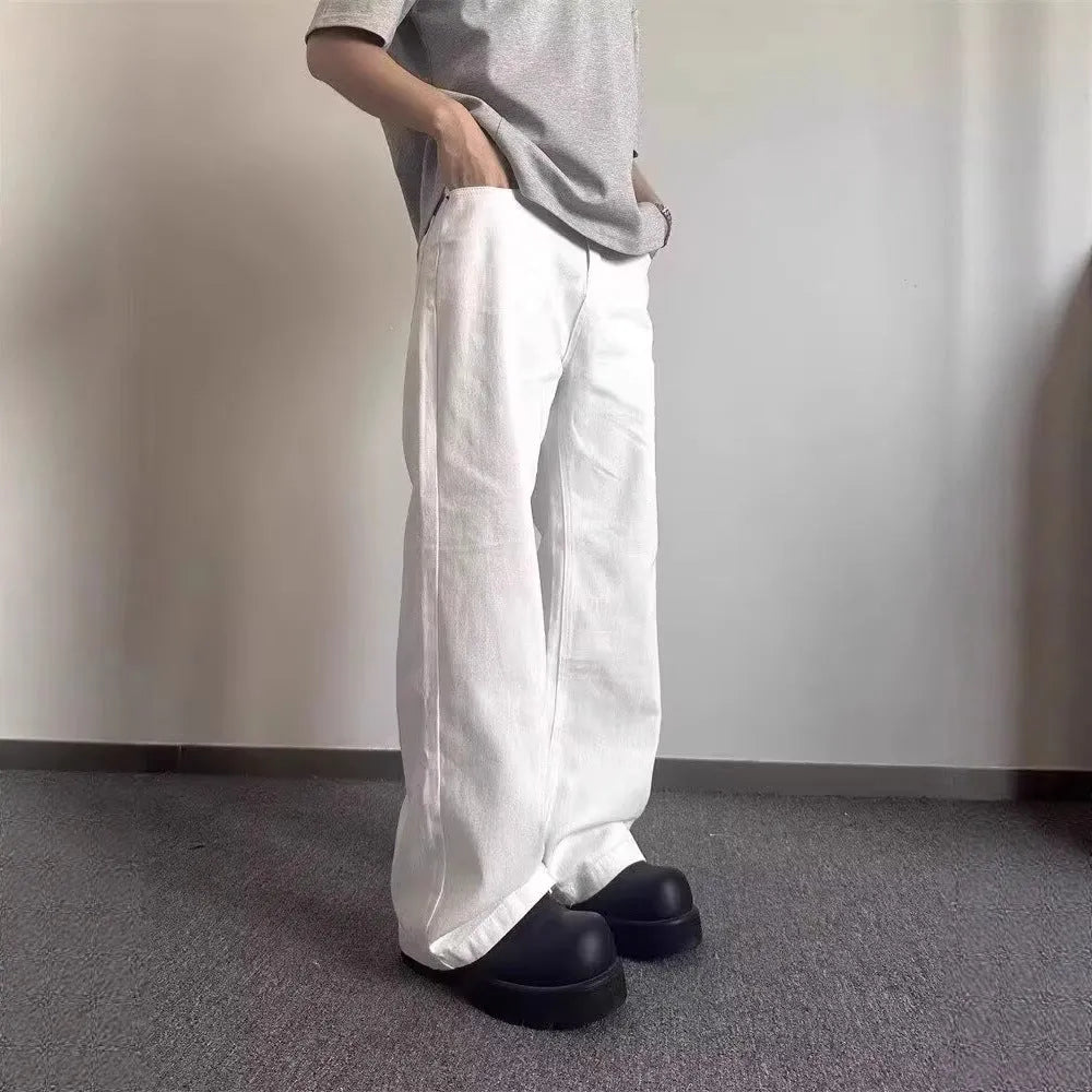 Men's loose fit straight wide leg white cotton denim jeans on a mid waist, showing zipper fly.