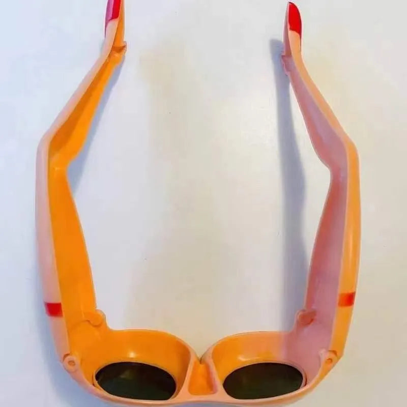 Orange novelty personality sunglasses with leg and hip design, measuring 15cm wide.