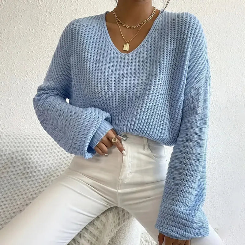 A woman's loose-fitting long sleeve pullover top in a solid colour.
