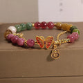 Close-up of a women's agate bracelet with a jade green tourmaline butterfly gourd bead.