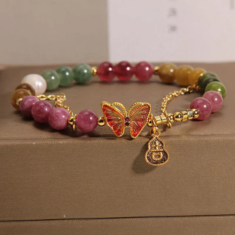 Close-up of a women's agate bracelet with a jade green tourmaline butterfly gourd bead.