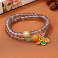 Natural gray agate two-circle bracelet on an adjustable cord, showing hand-polished stone detail.