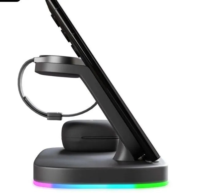 Vertical 3-in-1 wireless charging stand for mobile phone, smartwatch, and headphones on a desk.