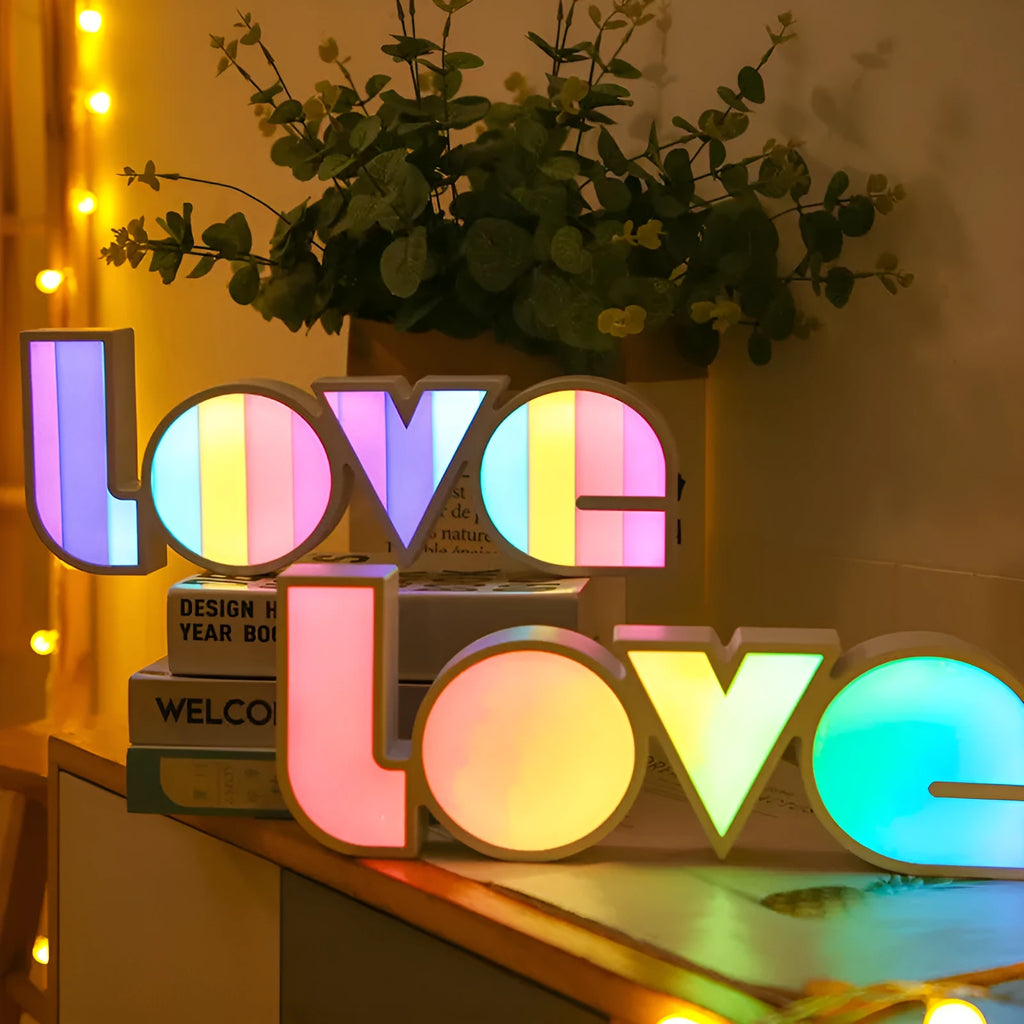 LED Love light with rainbow 'LOVE' lampshade on a table.