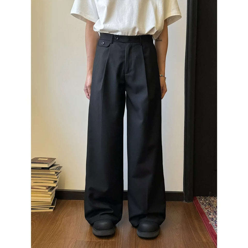Man wearing solid colour straight-leg casual suit trousers with a loose wide-leg draping fit.
