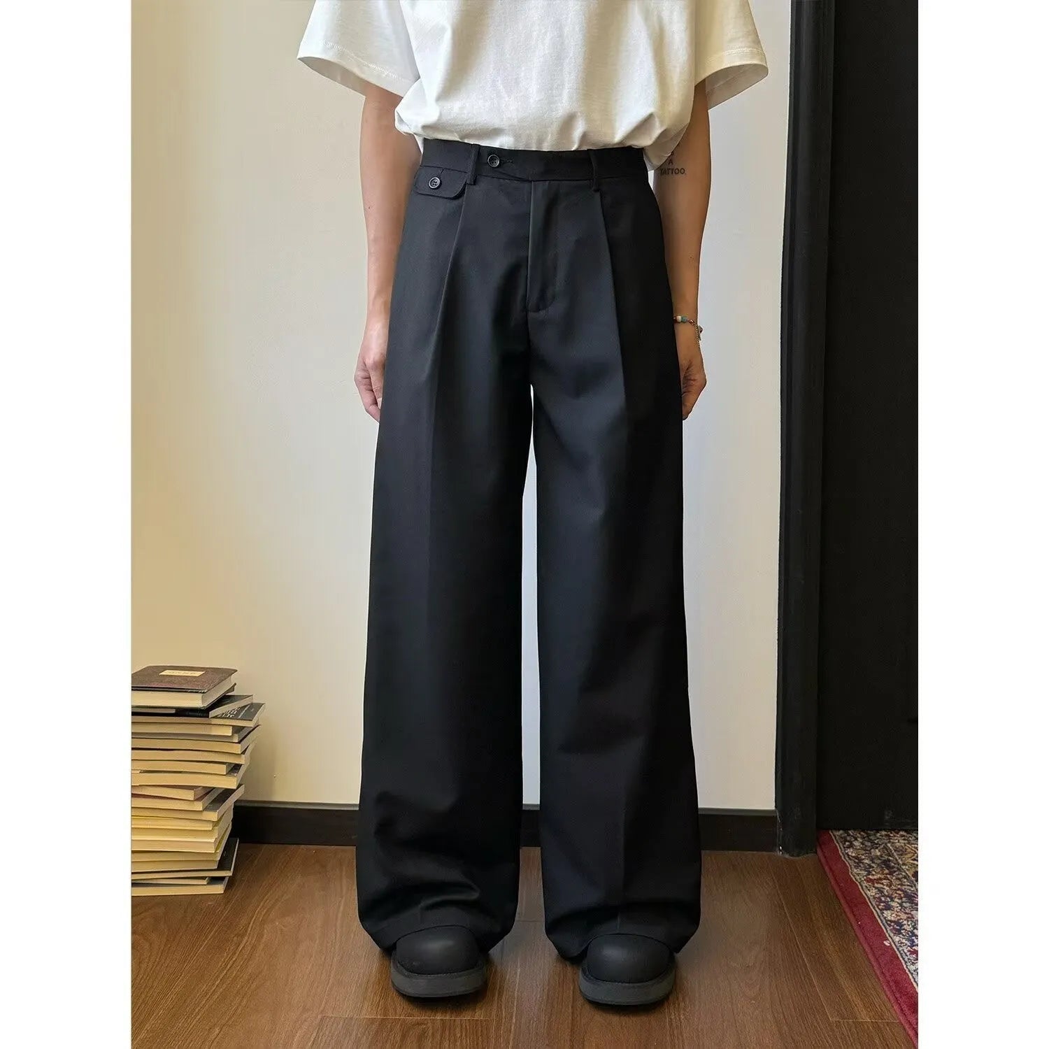 Man wearing solid colour straight-leg casual suit trousers with a loose wide-leg draping fit.
