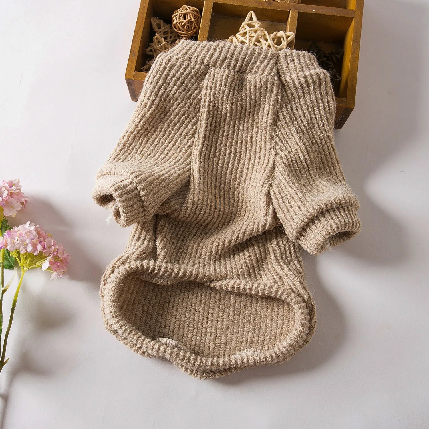 Brown knitted pullover sweater on a small dog, showing casual cloth design.