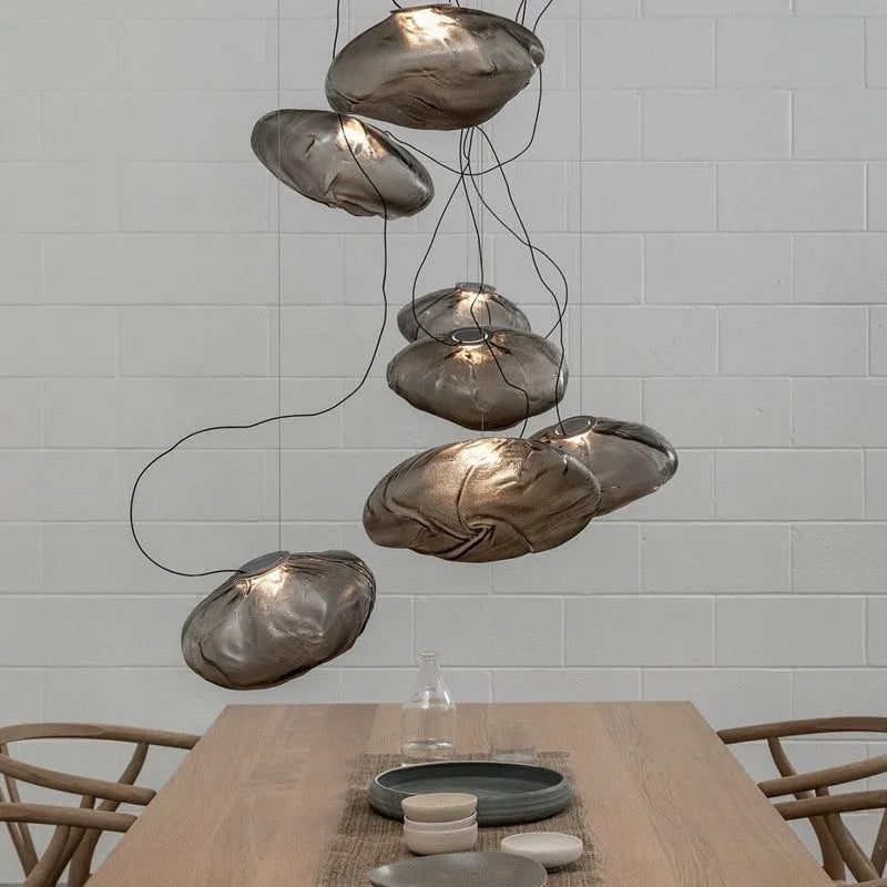 Postmodern glass decorative chandelier with a fabric design, shown in clear and smoke grey light options.