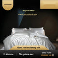 Solid colour silk quilt cover set with pillowcases on a bed, shown in a light luxury style.