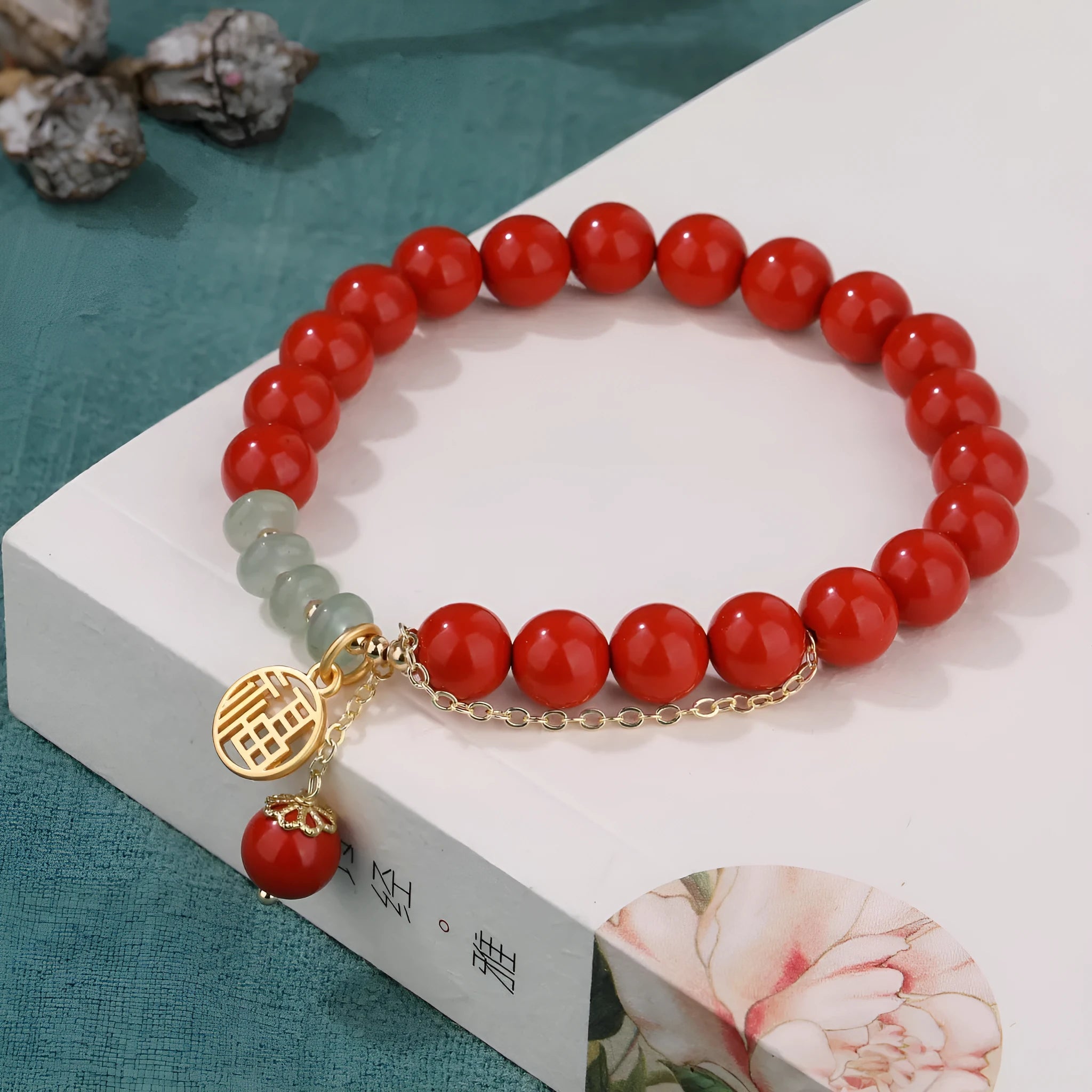 Handcrafted red sand cinnabar bracelet with fu character charm, jade spacer beads, and tassel decoration