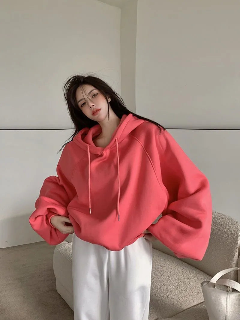 Watermelon red women's sleeveless hooded sweater made from mulberry silk on a hanger.