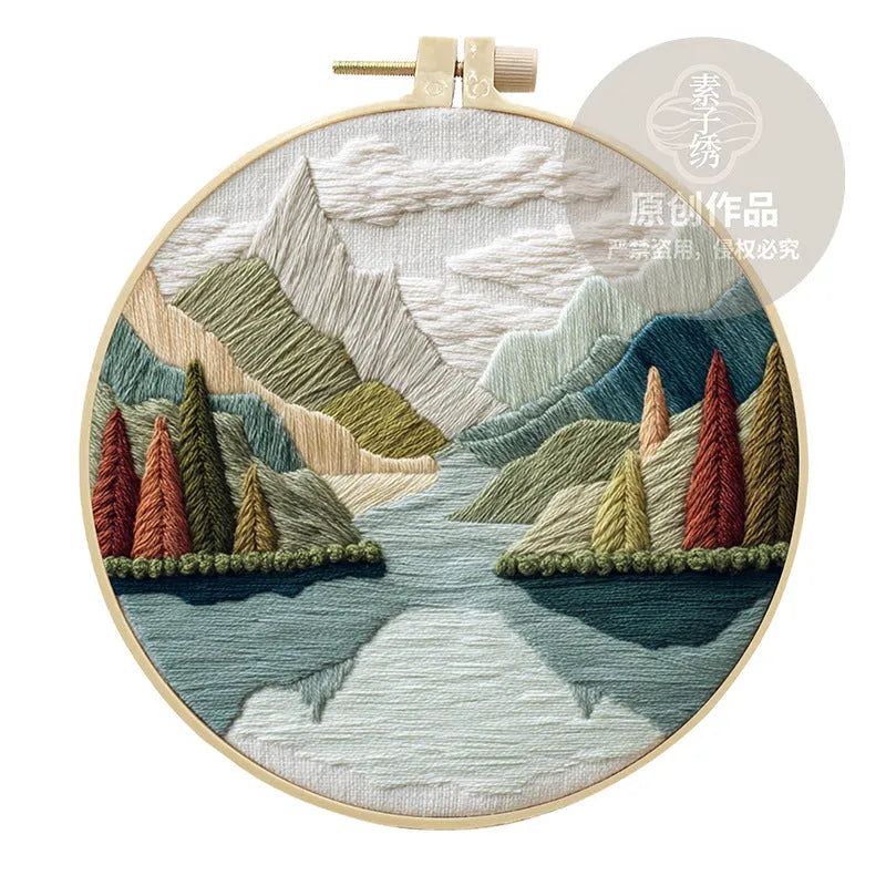 Embroidery DIY kit with cotton fabric, bamboo frame, scissors, and printed landscape pattern