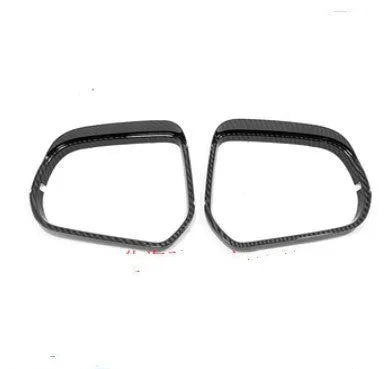 A pair of plastic rearview mirror protection covers in a carbon fibre black finish.