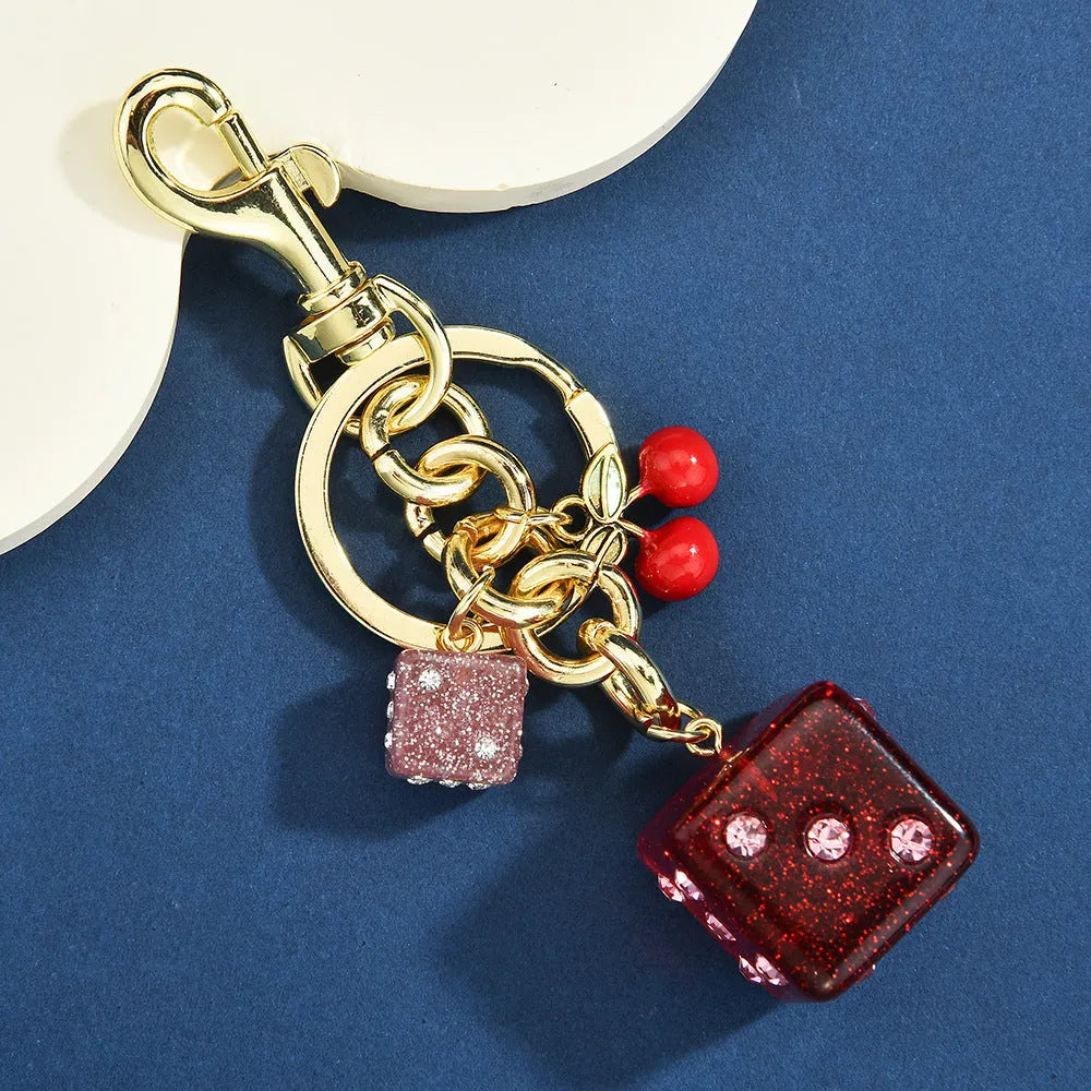 Square metal keychain pendant with a vintage cherry two-tone dice pattern and electroplated finish.