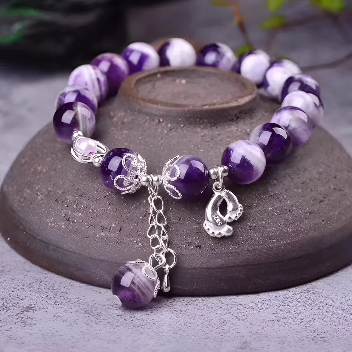 Close-up of a natural amethyst bracelet with 10mm round purple beads on a wrist.