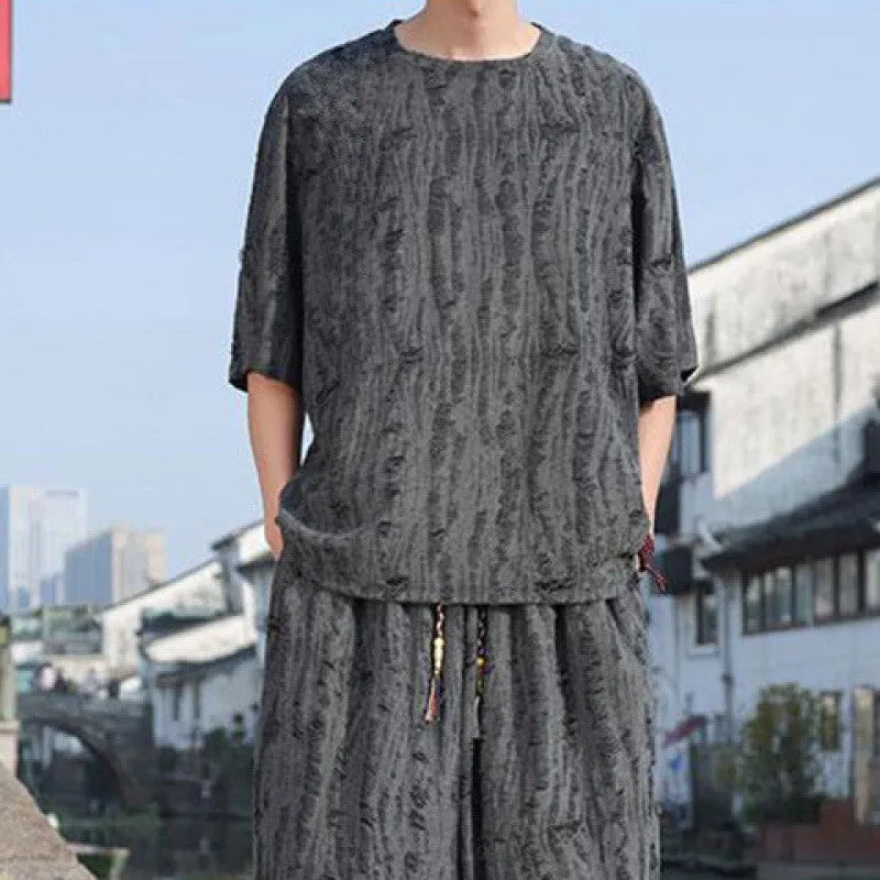 Men's lightweight knitted two-piece suit with short sleeves and cropped trousers in grey.