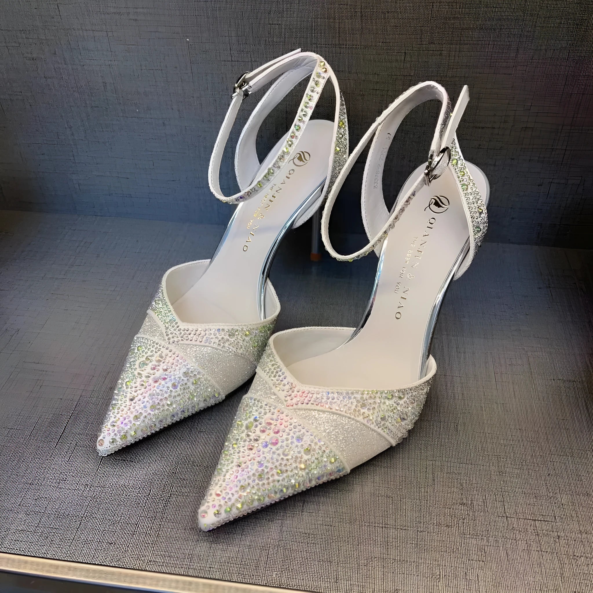 Women's black hollow high heel court shoe with red sole and pointed toe, stiletto heel.