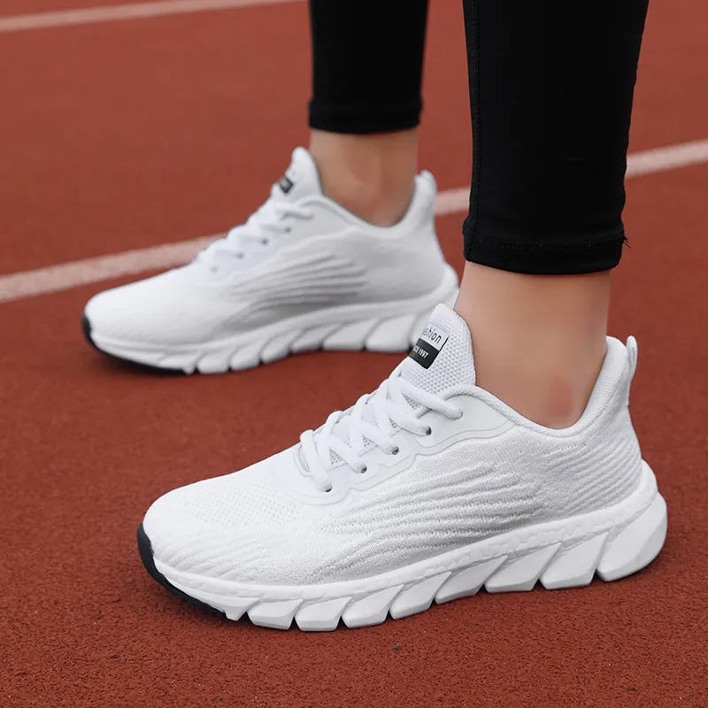 Low-top black and white running sneakers with cross-strap detail and a round toe on a flat MD sole.