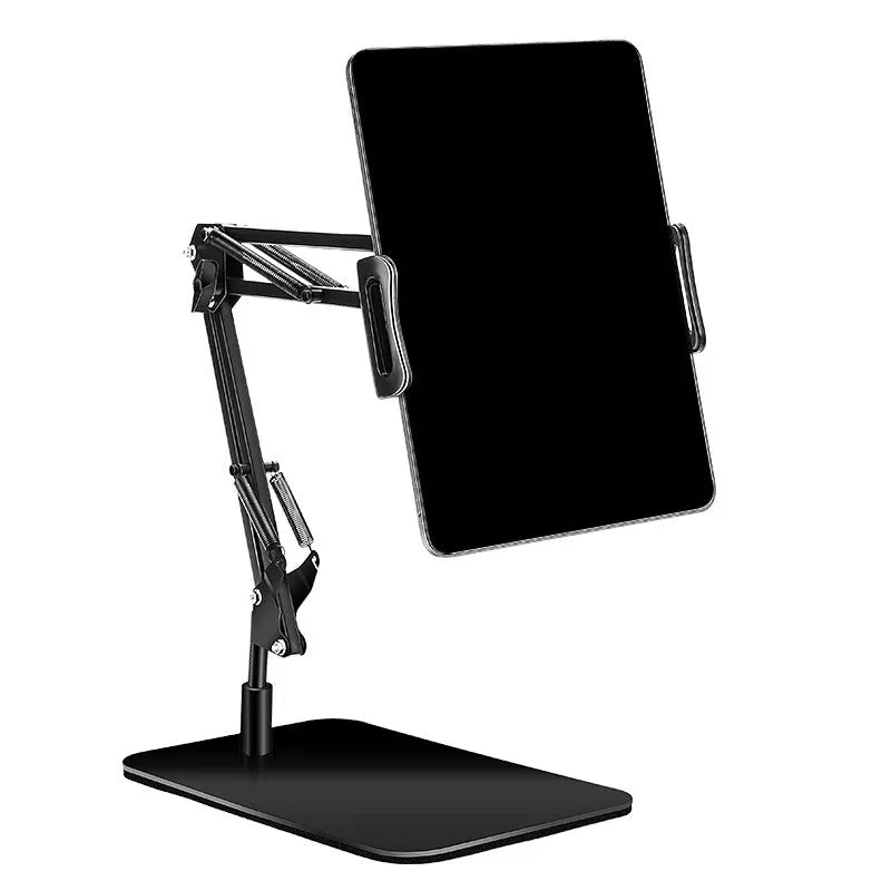 Black universal phone stand with long rotating metal arms and a heavy round base on a wooden desk.